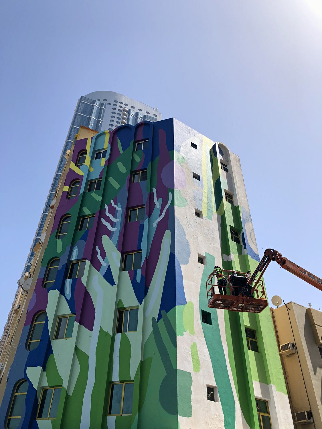 The completed Ajman mural seen across the full building