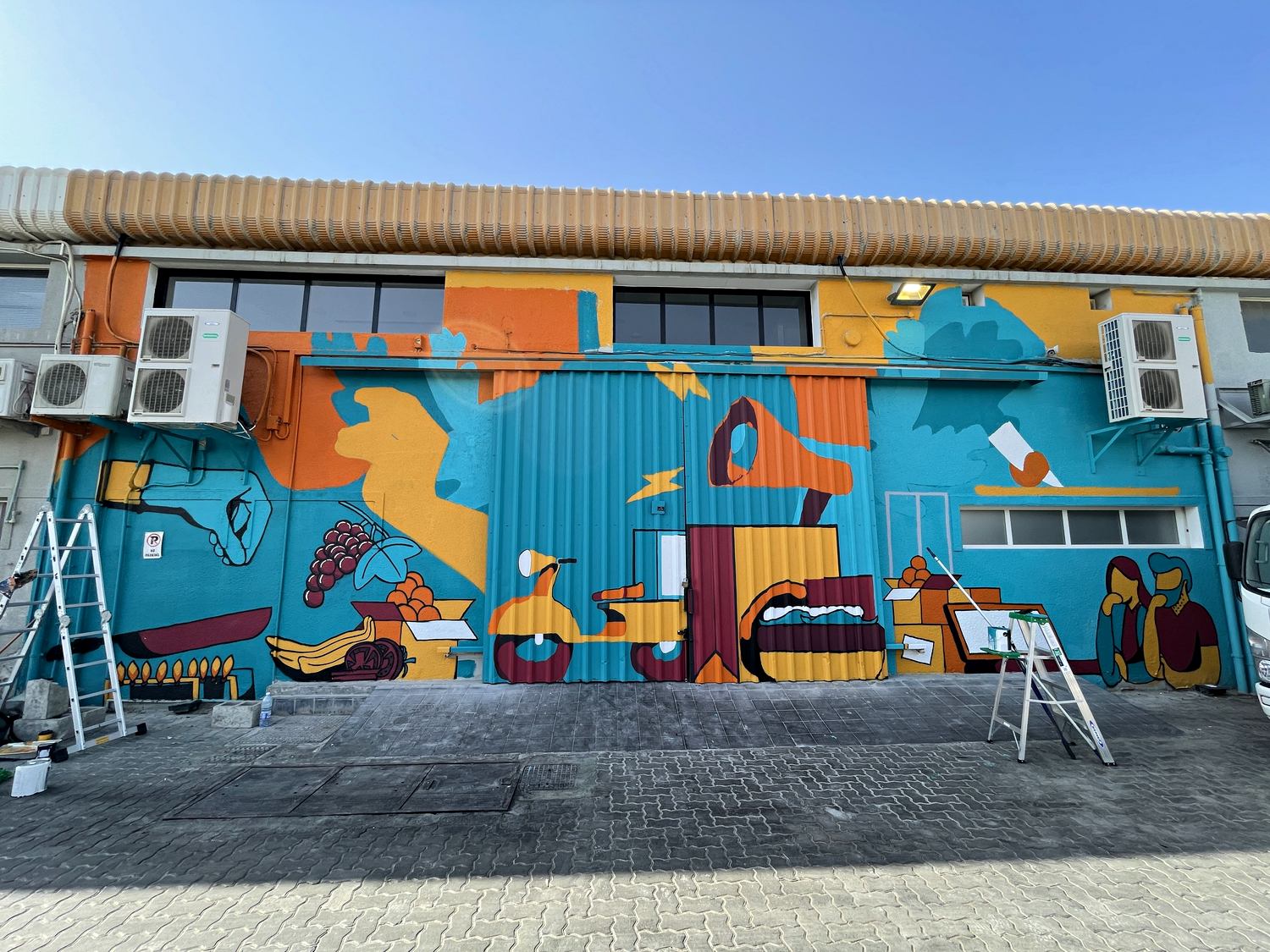 Kitopi headquarters mural being painted across the warehouse frontage