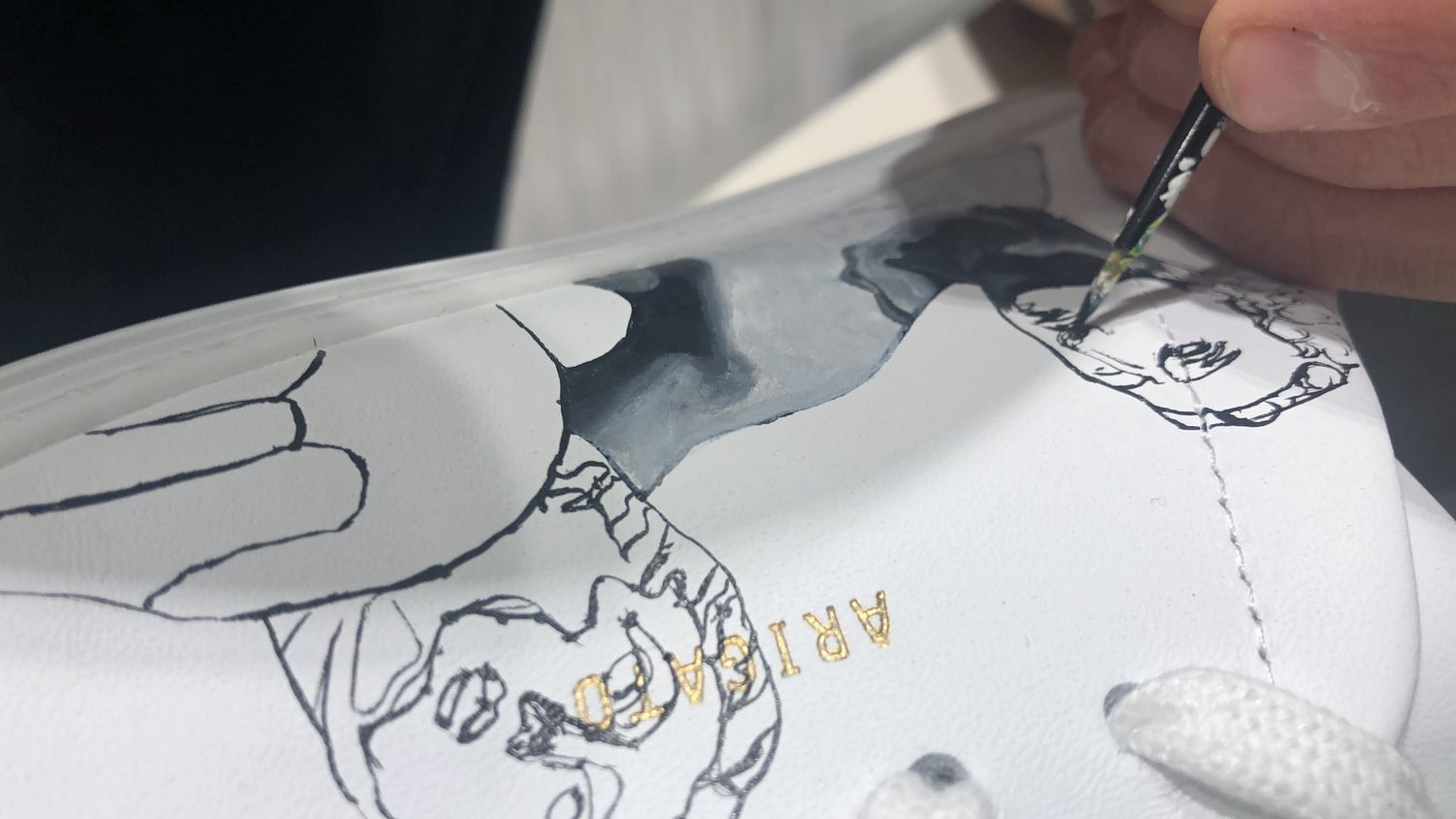 Artist painting a shoe during the Level Shoes activation