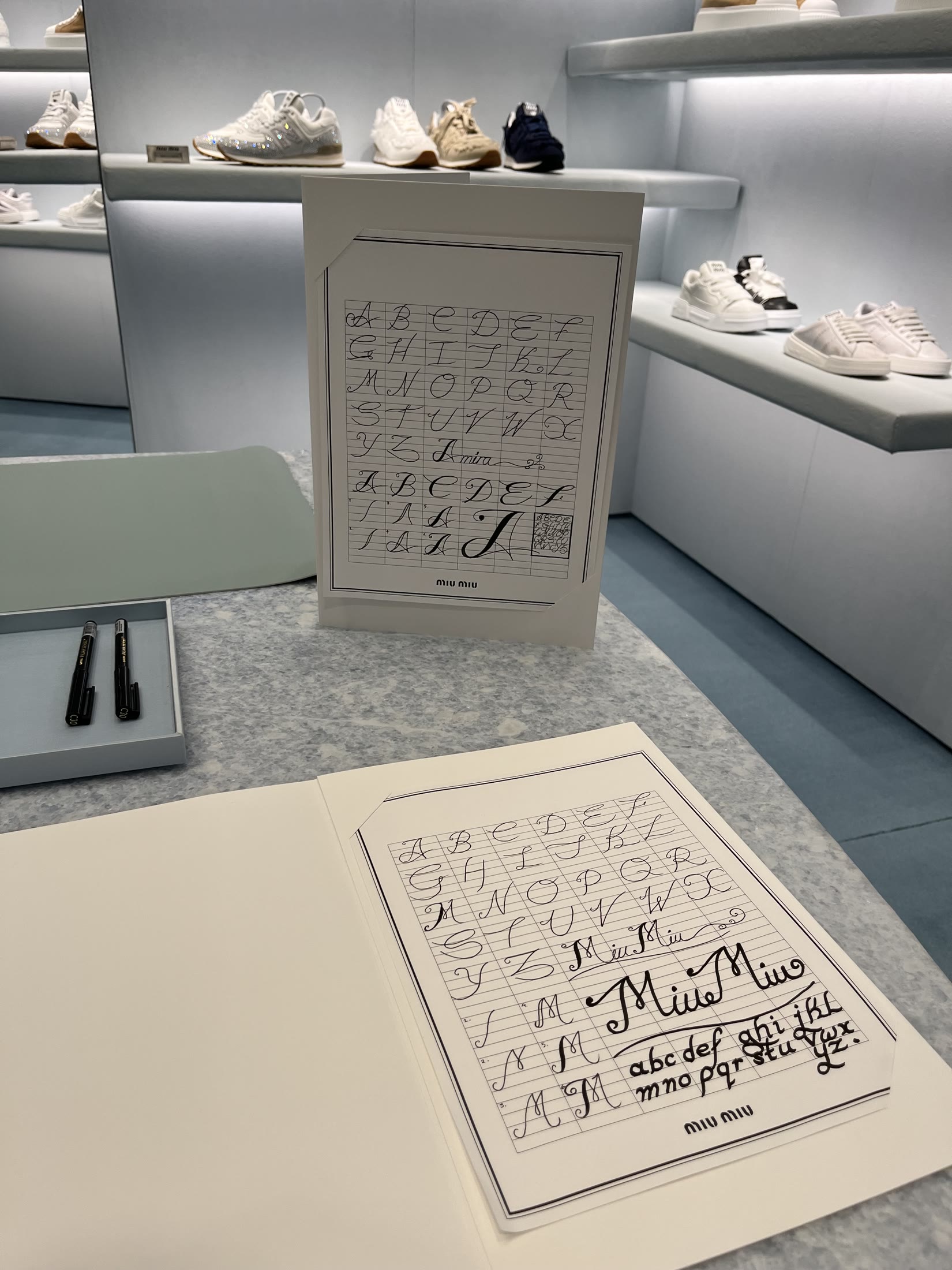 Miu Miu calligraphy samples displayed at the artist station