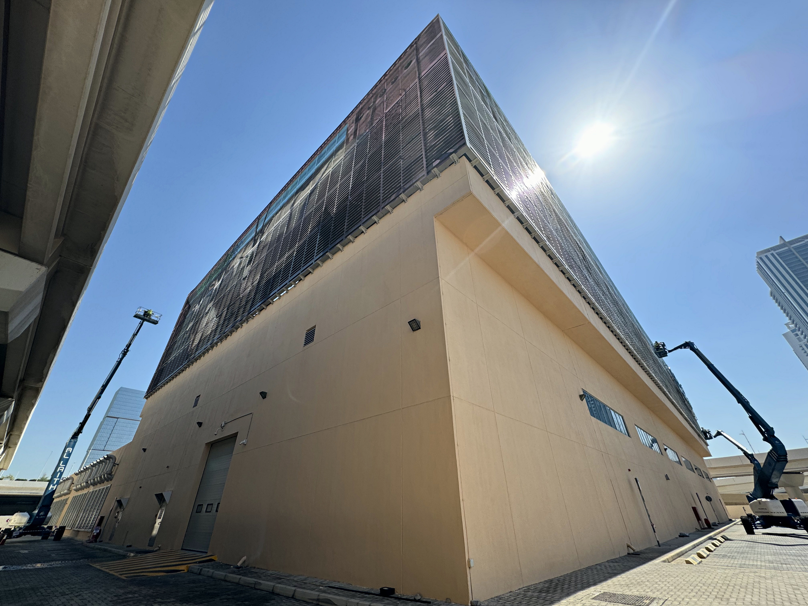 Low-angle view showing the full height of the Tabreed building and access equipment