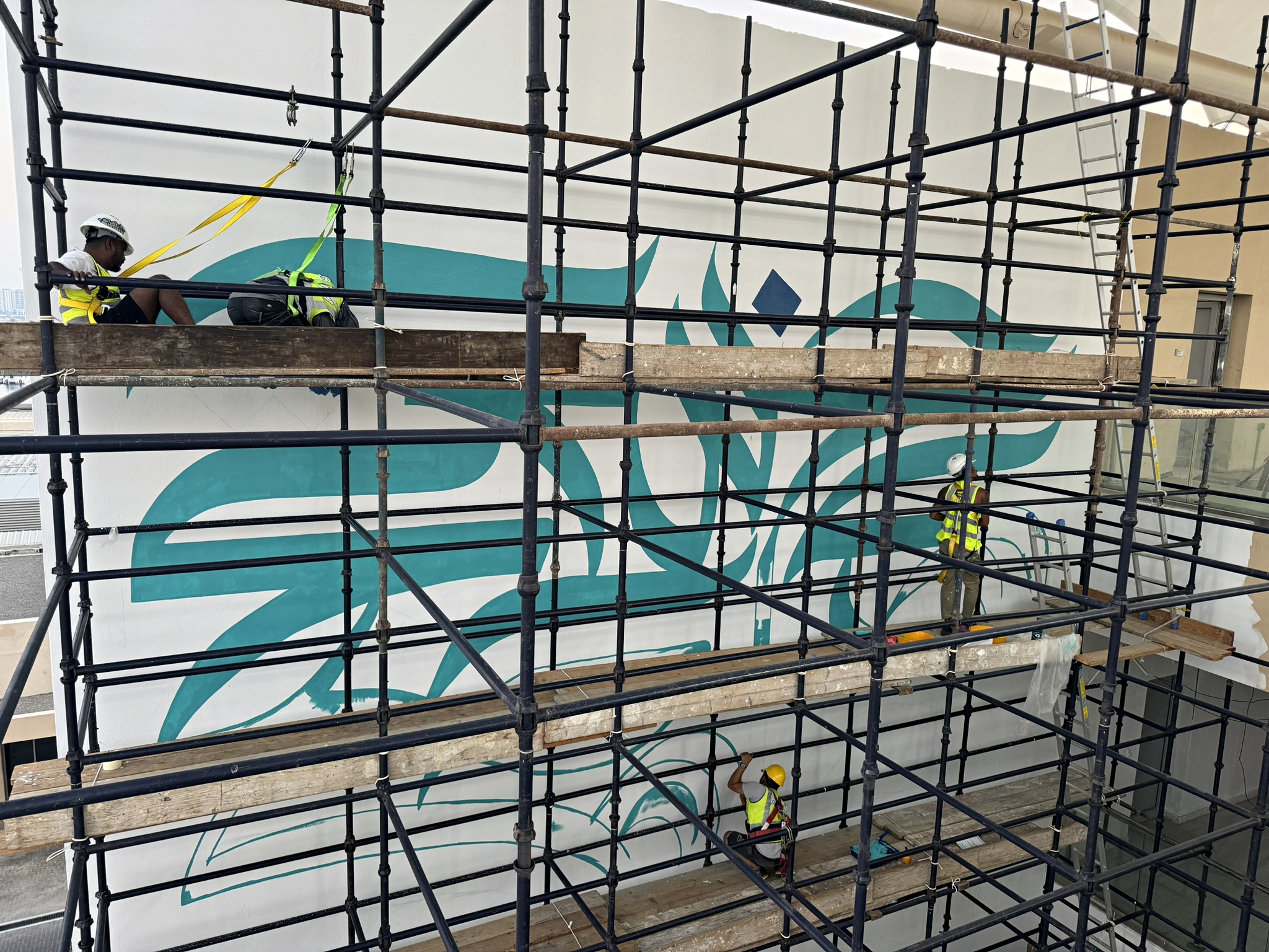 Gallery Dod mural crew working across aligned full-height scaffolding at Yas Marina Circuit