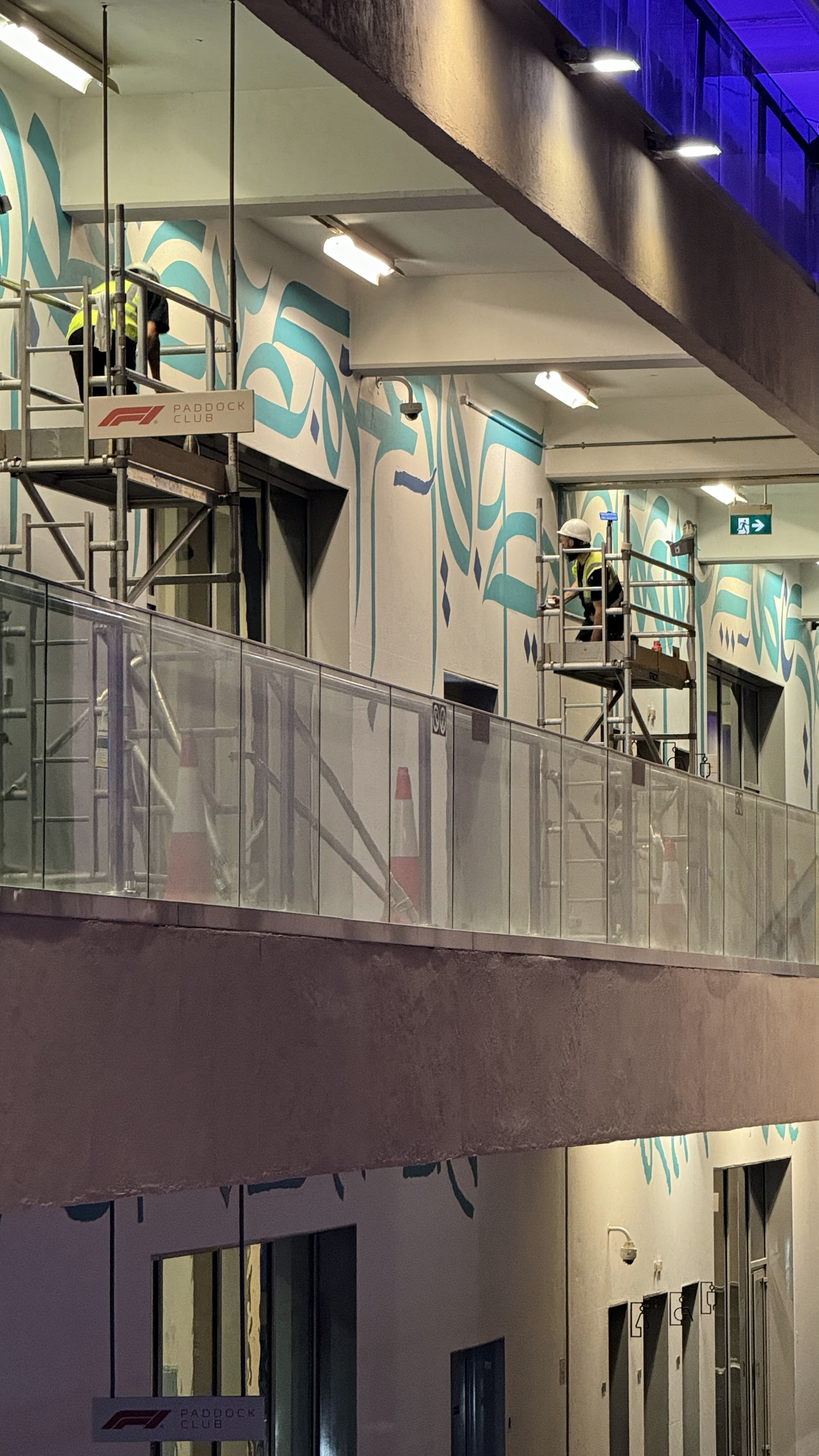 Artists working across multiple levels of the Paddock Club at night