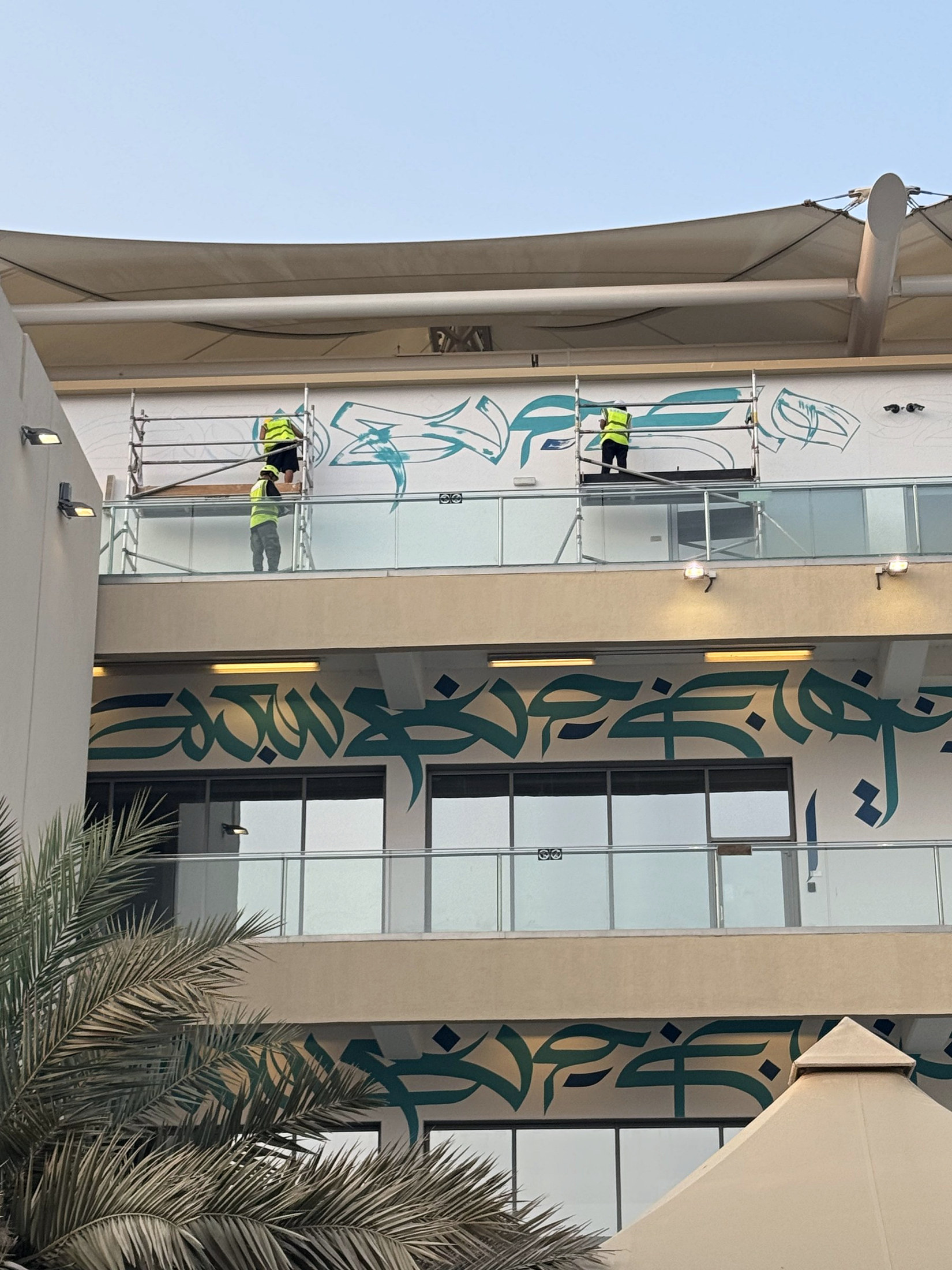 Artists working from scaffold across two Paddock Club levels