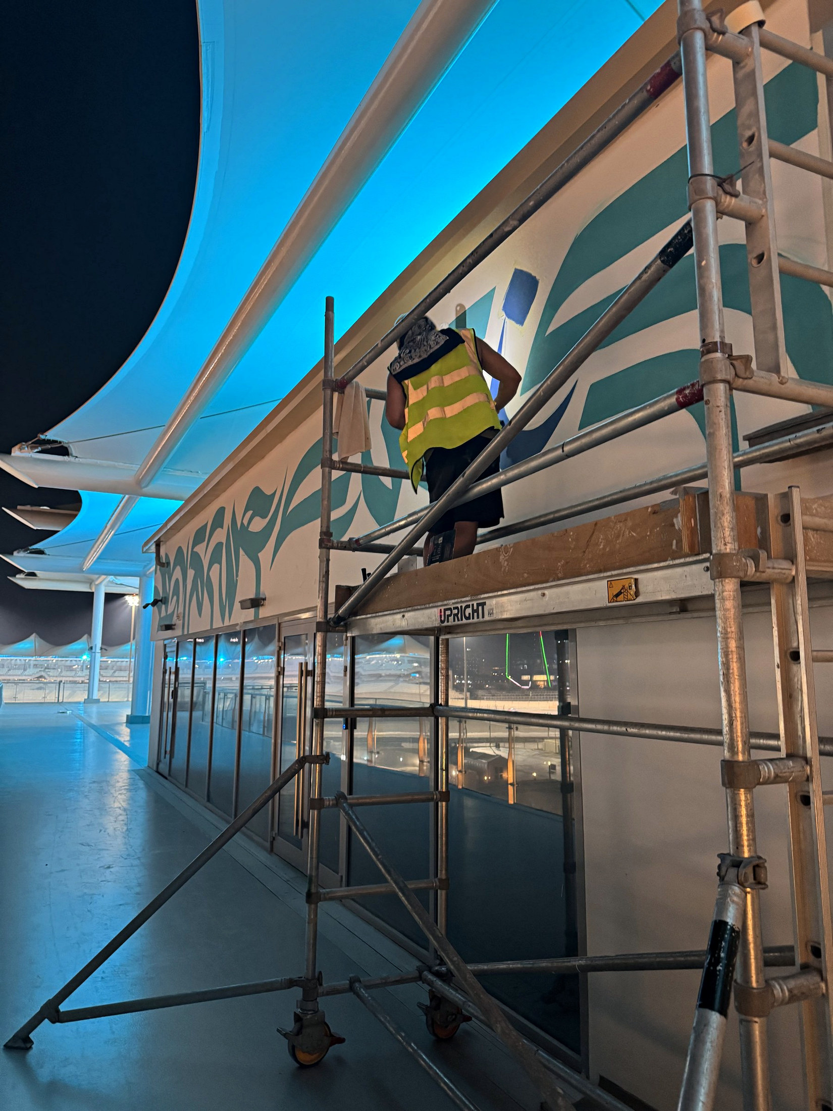 Artist painting from a scaffold at dusk
